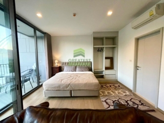 ห้องนอนคอนโดเดอะวัลลีย์ เขาใหญ่ พร้อมประตูกระจกสไลด์และพื้นลามิเนต